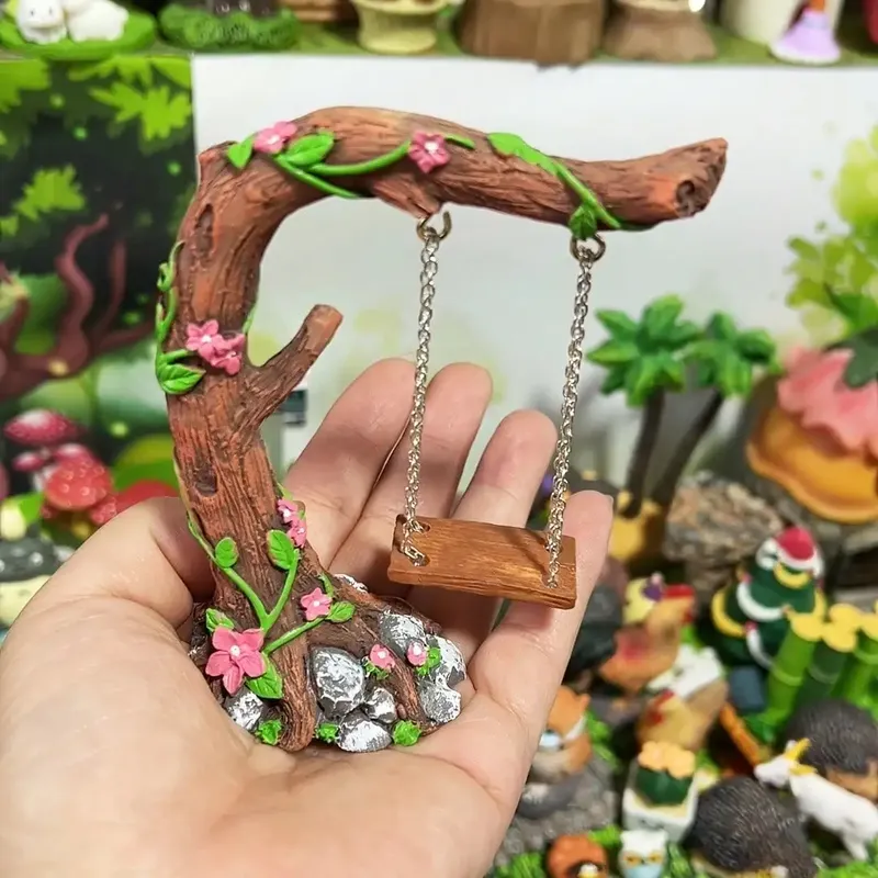 Verschiedene bunte kleine Bäume im Freien, Gartendekoration mit Schaukeln und Blumen, kleine Statuenornamenten, einzigartige Geschenke im ländlichen Stil